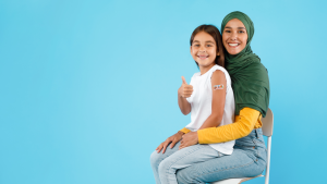A child sits on her mother's lap after receiving the HPV vaccine