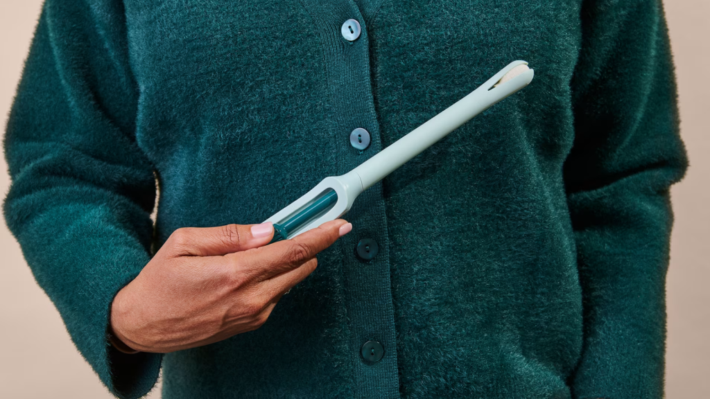 A woman holds a Teal Wand, a device for at-home HPV testing