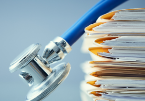 A stethoscope hangs over medical files
